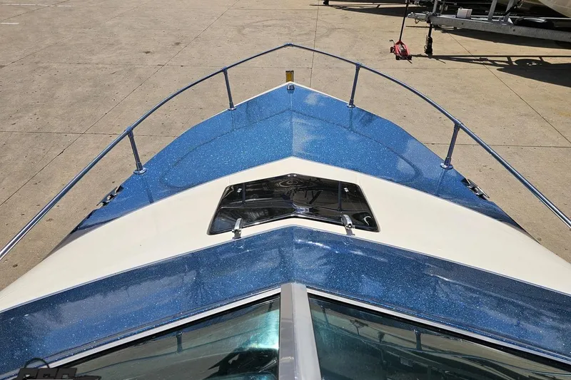 Slide: The Image of 1988 Glastron/Carlson CVX-23 boat with blue and white deck, docked on concrete. - 58