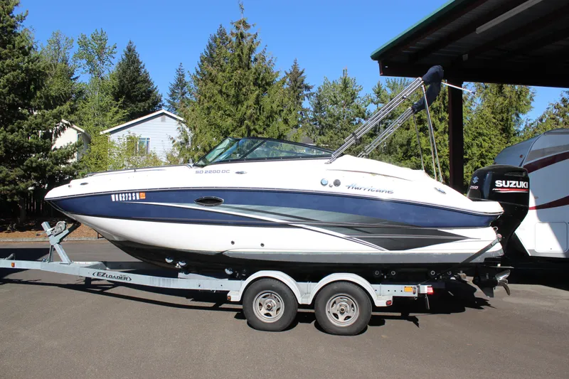 The Image of 2018 Hurricane SunDeck 2200 DC OB boat on trailer, parked outdoors. - 1