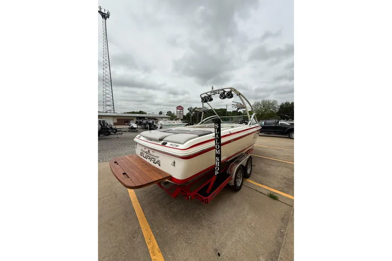 Slide: The Image of 2005 Supra Sunsport 24 V boat on trailer, parked outdoors under cloudy sky. - 4