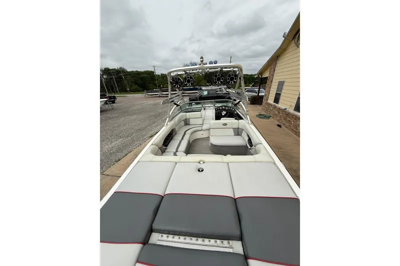 Slide: The Image of 2005 Supra Sunsport 24 V boat interior with seating and speakers, parked outdoors. - 8