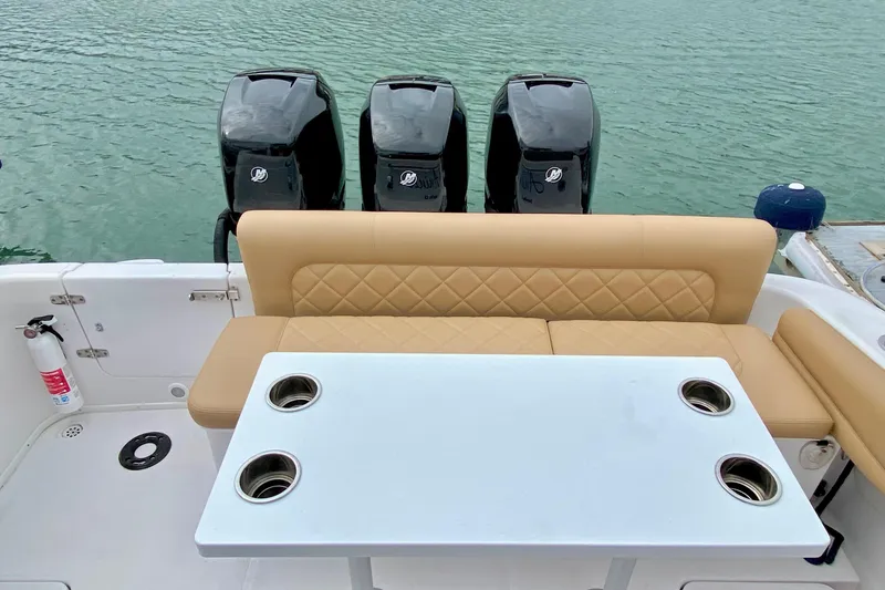 Slide: The Image of 2006 Donzi 38 ZSF boat interior with seating, table, and triple outboard motors. - 14