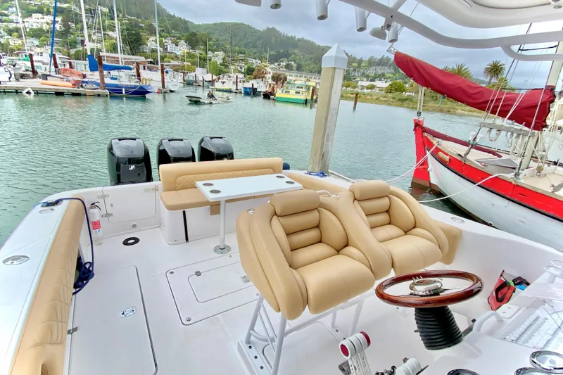 Slide: The Image of 2006 Donzi 38 ZSF boat interior with beige seating, docked in a scenic marina. - 15