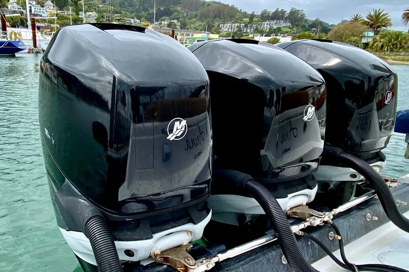 Slide: The Image of Triple Mercury outboard engines on a 2006 Donzi 38 ZSF boat, docked in a scenic marina. - 16