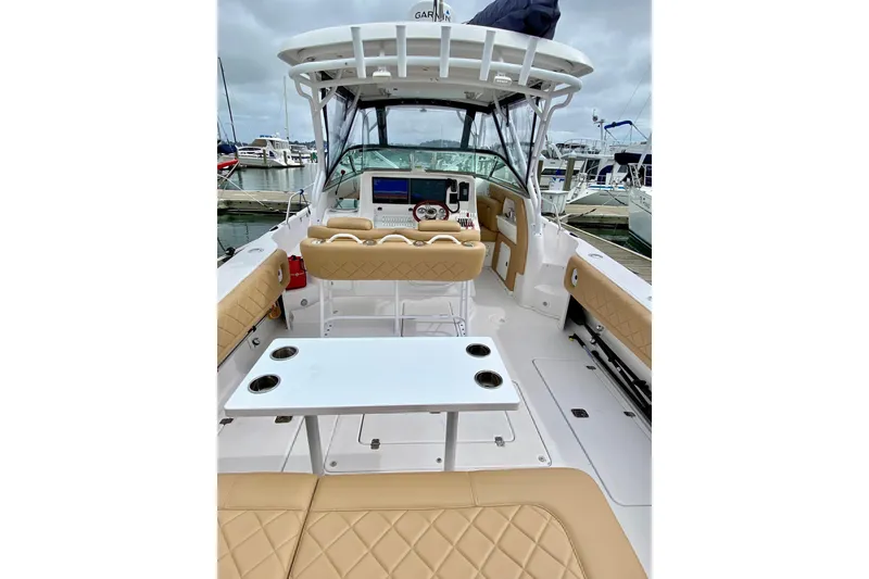 Slide: The Image of 2006 Donzi 38 ZSF boat interior with beige seating and white table at marina. - 20