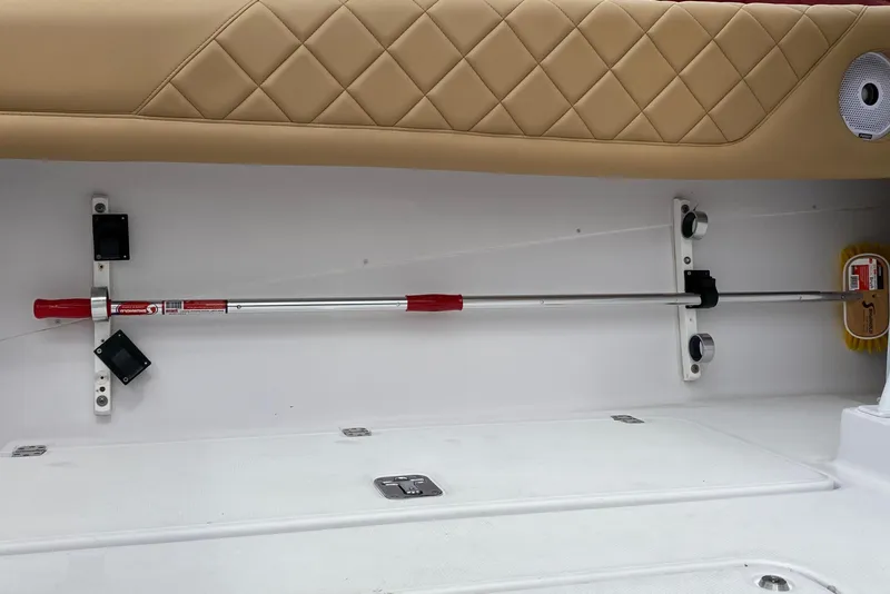 Slide: The Image of 2006 Donzi 38 ZSF interior with beige quilted upholstery and mounted cleaning tools. - 26