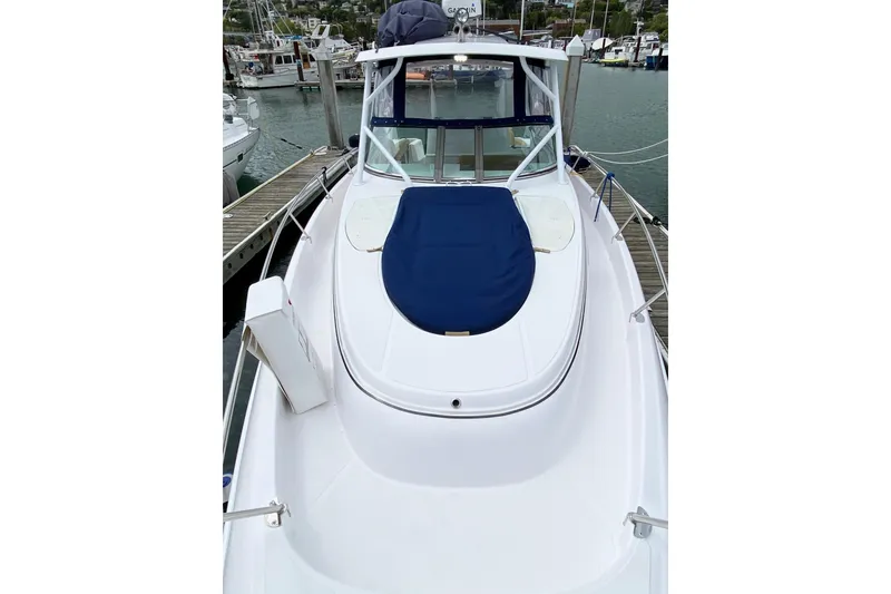 Slide: The Image of 2006 Donzi 38 ZSF boat docked at marina, featuring sleek white design and blue cover. - 35