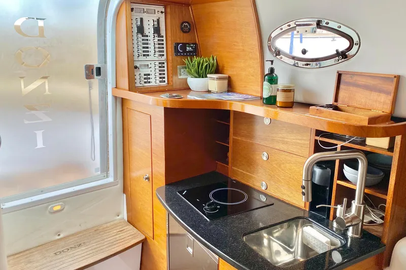 Slide: The Image of Luxurious 2006 Donzi 38 ZSF yacht interior with modern kitchenette and wooden cabinetry. - 46