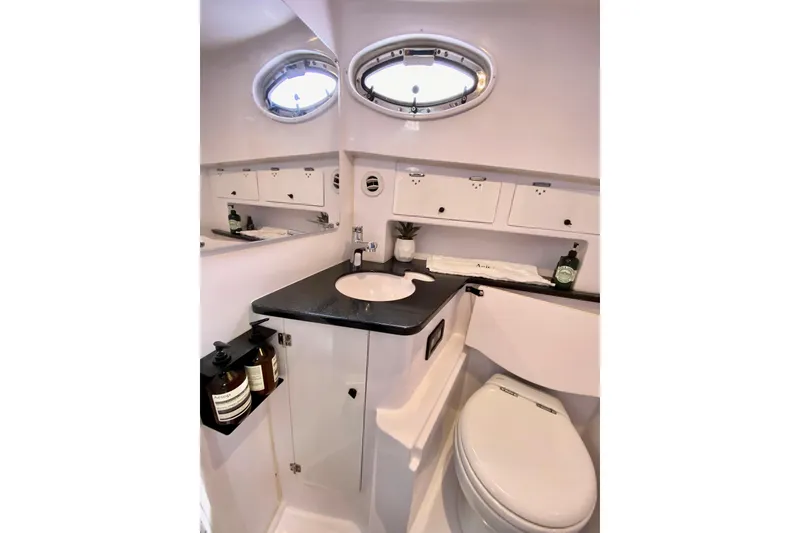 Slide: The Image of Luxurious bathroom interior of 2006 Donzi 38 ZSF boat with modern fixtures and porthole windows. - 60