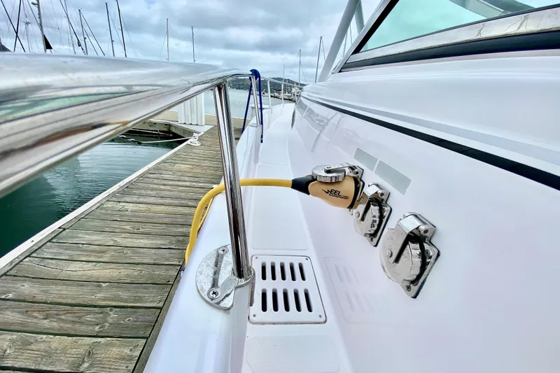 Slide: The Image of 2006 Donzi 38 ZSF boat docked, showing power connections and sleek white exterior. - 7
