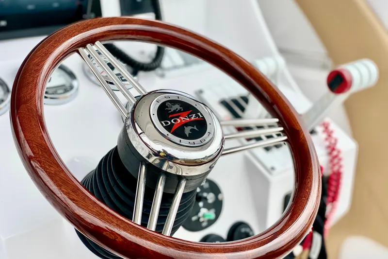 Slide: The Image of Steering wheel of a 2006 Donzi 38 ZSF boat, featuring a polished wood finish. - 9