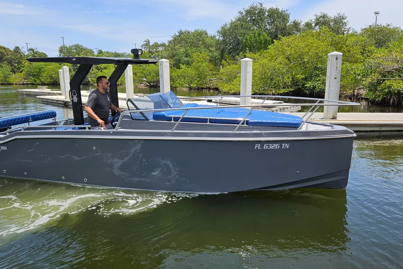 Slide: The Image of 2023 Argonaut 260 boat cruising near a dock with lush greenery. - 0