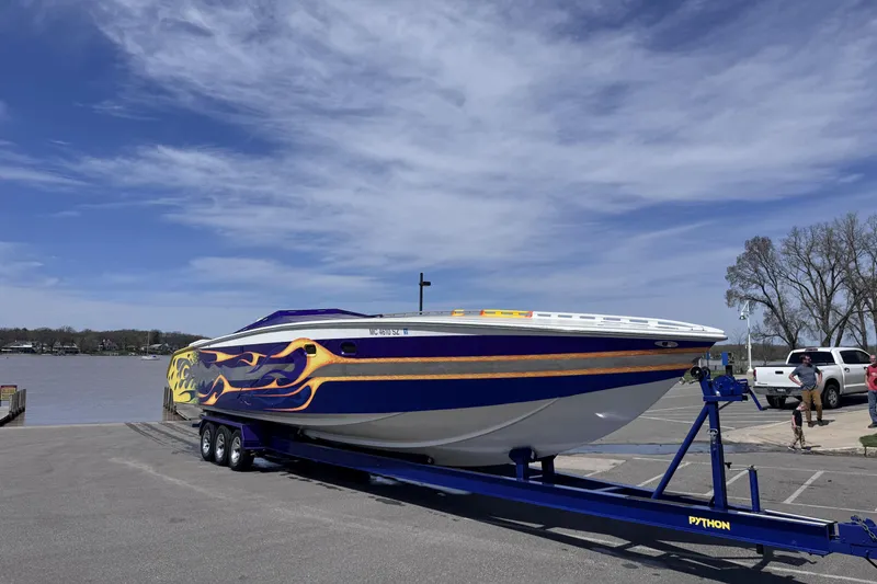Slide: The Image of 2000 Python Offshore boat with flame design on trailer by a lake. - 10