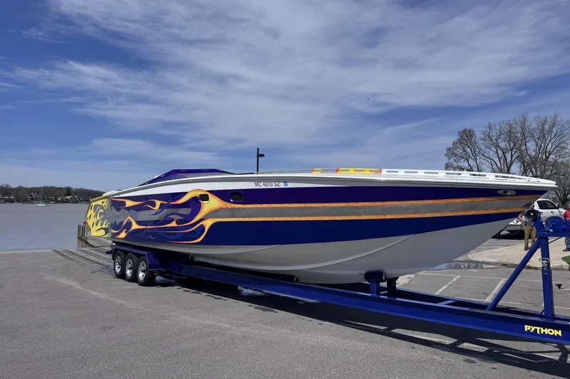 Slide: The Image of 2000 Python Offshore boat with flame design on trailer by a lake. - 11