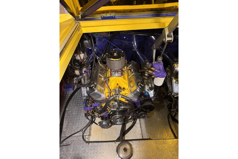 Slide: The Image of Engine compartment of a 2000 Python Offshore boat, featuring a vibrant yellow and purple engine. - 18