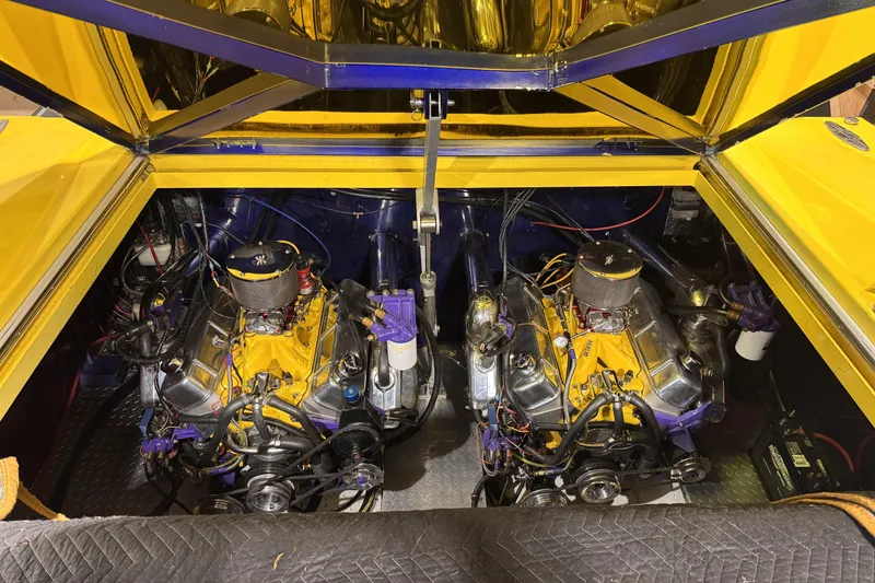 Slide: The Image of Twin engines in a 2000 Python Offshore boat, featuring vibrant yellow and purple accents. - 20