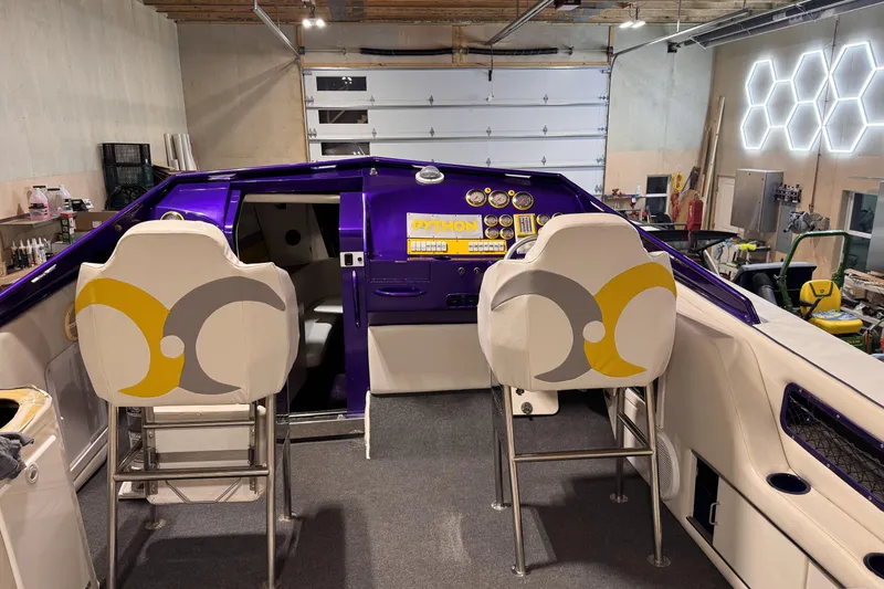 Slide: The Image of Interior of a 2000 Python Offshore boat with purple dashboard and stylish seating. - 22