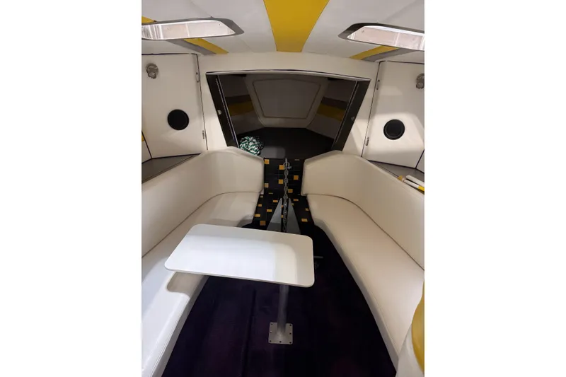 Slide: The Image of Interior of a 2000 Python Offshore boat with white seating and a small table. - 25