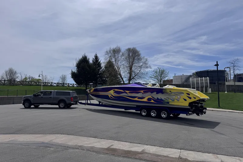 Slide: The Image of Truck towing a colorful 2000 Python Offshore boat on a trailer in a parking area. - 4