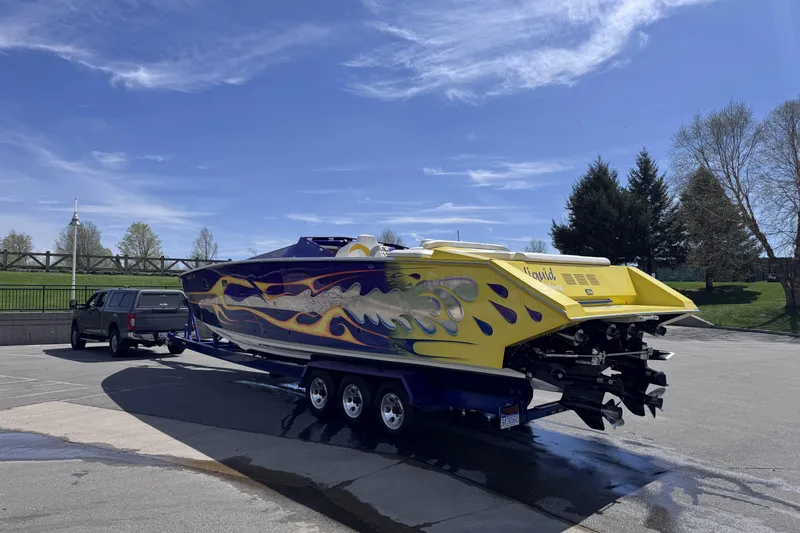 Slide: The Image of A 2000 Python Offshore boat with vibrant flame graphics on a trailer. - 7