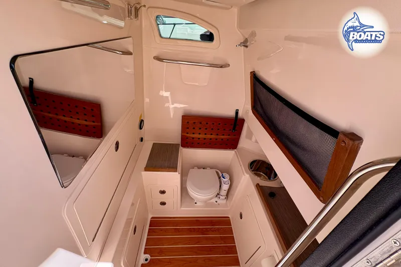Slide: The Image of 2021 Grady-White Canyon 306 boat helm with advanced navigation controls and steering wheel. - 12