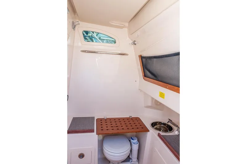 Slide: The Image of 2021 Grady-White Canyon 306 boat interior with seating and storage, docked at marina. - 13