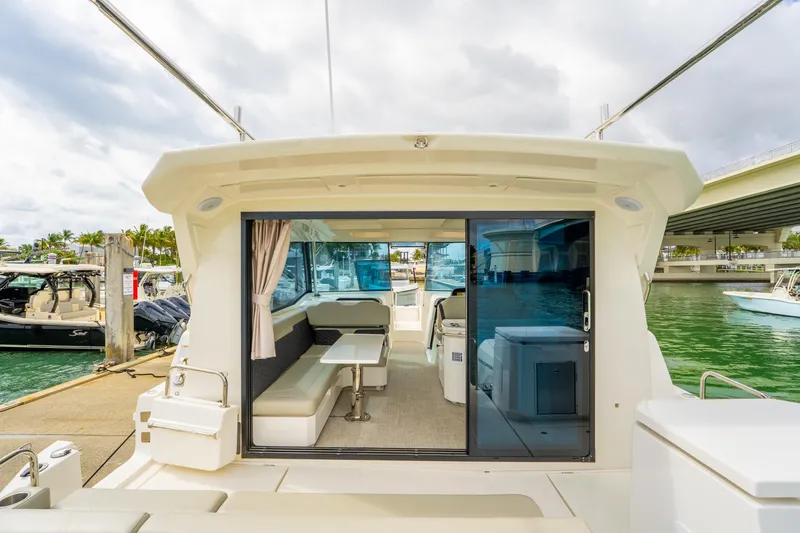 Slide: The Image of Aquila 36 Cruiser 2025 yacht interior with seating and table, docked by the water. - 11