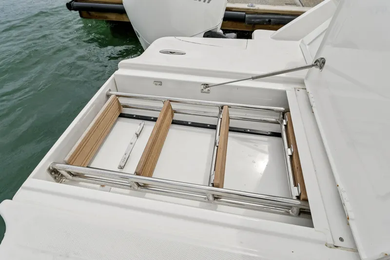 Slide: The Image of Aquila 36 Cruiser 2025 swim platform with retractable ladder by the water. - 15