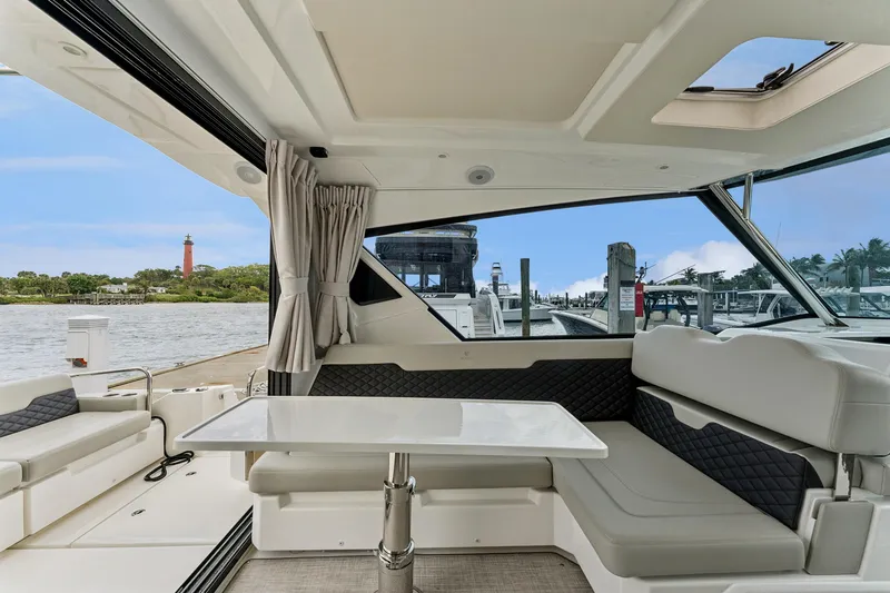 Slide: The Image of Interior of 2025 Aquila 36 Cruiser with seating and table, overlooking marina. - 19