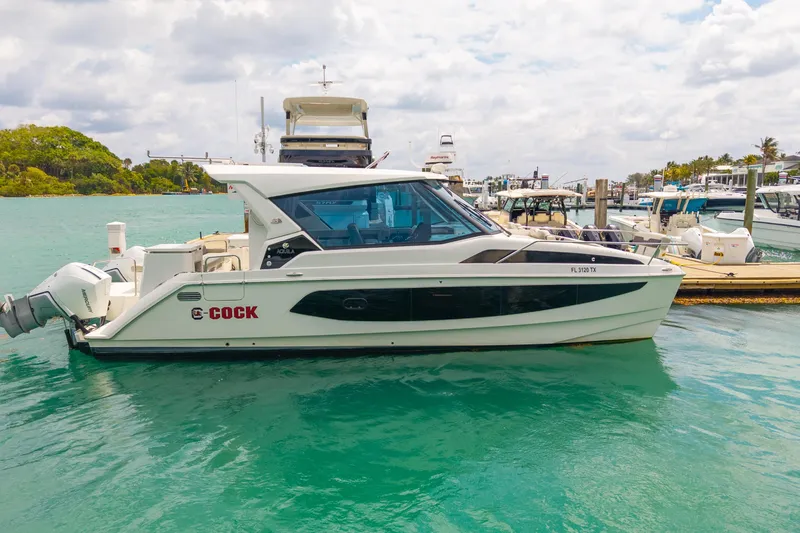 Slide: The Image of 2025 Aquila 36 Cruiser docked in a marina, featuring sleek design and modern amenities. - 2