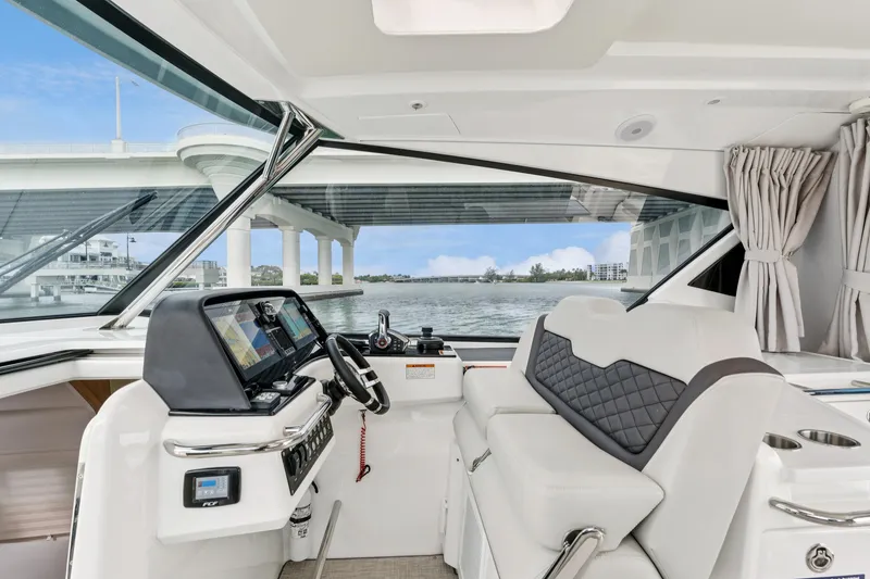 Slide: The Image of Interior view of 2025 Aquila 36 Cruiser helm with modern controls and waterfront backdrop. - 28