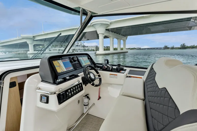 Slide: The Image of Interior view of 2025 Aquila 36 Cruiser helm with bridge in background. - 29