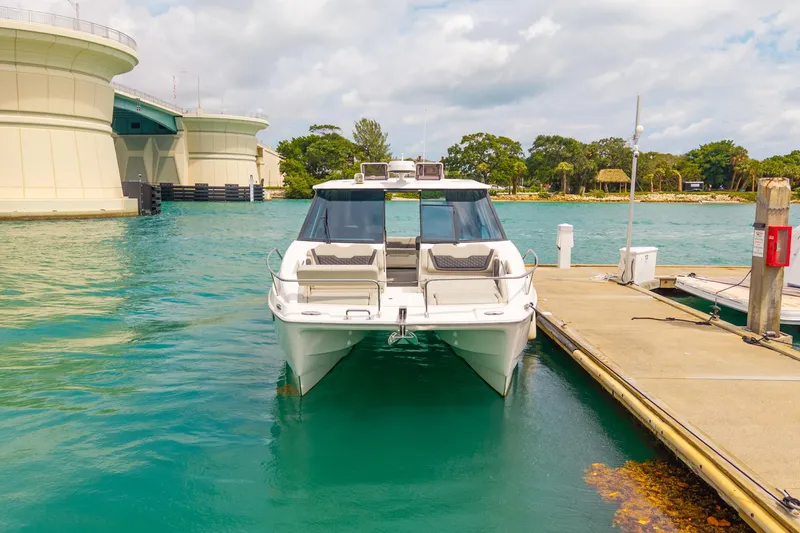 Slide: The Image of 2025 Aquila 36 Cruiser docked in a serene marina setting. - 3