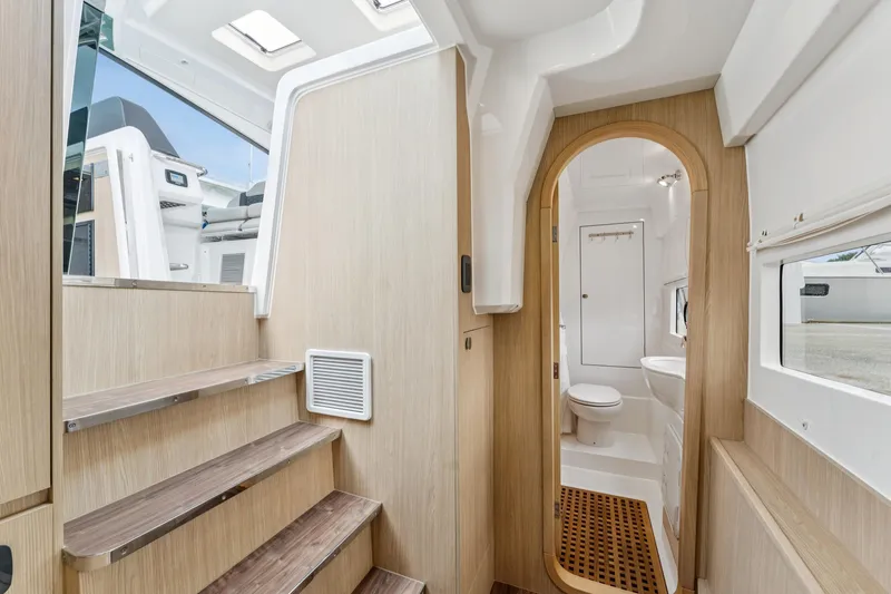Slide: The Image of Interior of 2025 Aquila 36 Cruiser, featuring wooden stairs and modern bathroom. - 36
