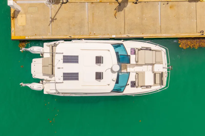Slide: The Image of Aquila 36 Cruiser 2025 docked, aerial view, turquoise water, solar panels visible. - 4