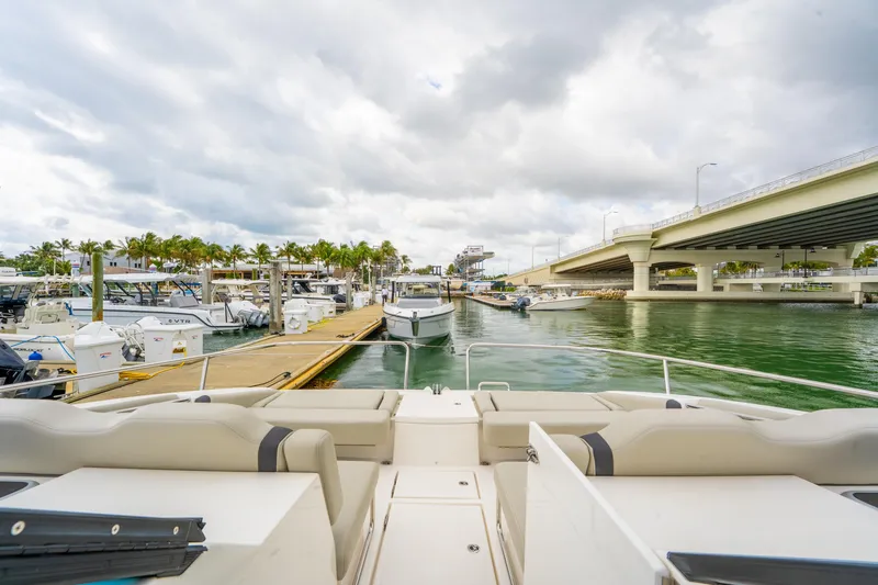 Slide: The Image of 2025 Aquila 36 Cruiser docked near a marina under a cloudy sky. - 46