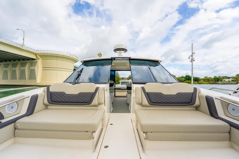 Slide: The Image of 2025 Aquila 36 Cruiser luxury yacht with spacious seating, docked near a bridge under a cloudy sky. - 48