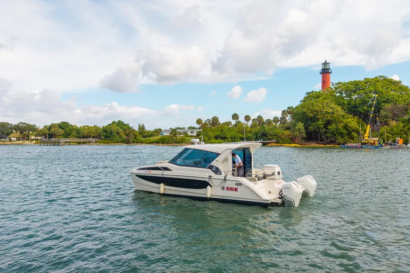 Slide: The Image of 2025 Aquila 36 Cruiser on water near a lighthouse and lush greenery. - 52