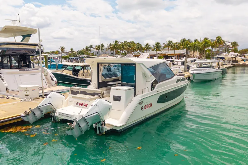 Slide: The Image of Aquila 36 Cruiser 2025 docked at marina, surrounded by other boats and palm trees. - 53