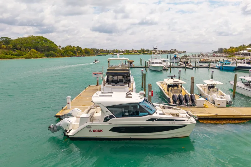 Slide: The Image of Aquila 36 Cruiser 2025 docked at a marina with turquoise waters and boats. - 6