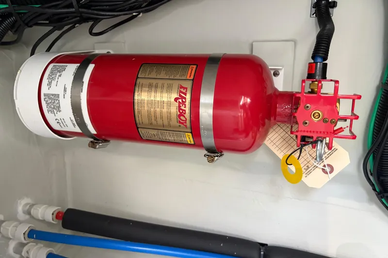 Slide: The Image of Fire extinguisher in 2025 Aquila 36 Cruiser engine compartment, mounted securely with safety tag. - 63