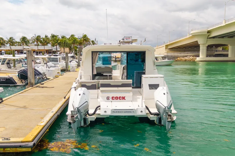 Slide: The Image of 2025 Aquila 36 Cruiser docked in a marina, surrounded by clear turquoise water. - 7