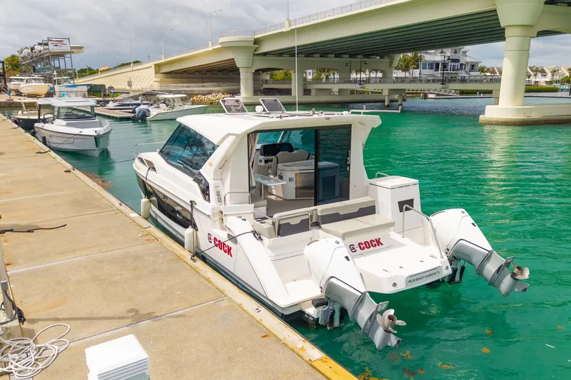 Slide: The Image of 2025 Aquila 36 Cruiser docked by a bridge in turquoise waters. - 8