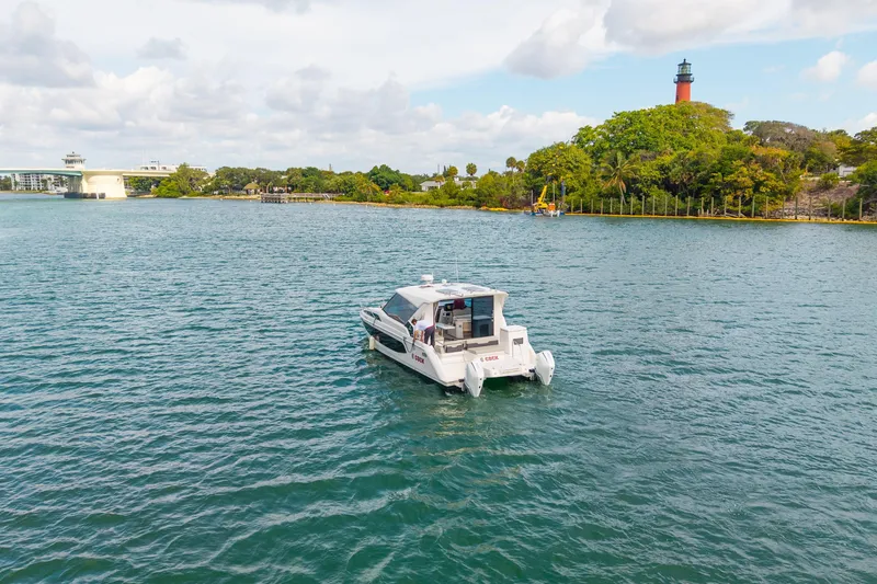 Slide: The Image of Aquila 36 Cruiser 2025 on scenic waterway near lighthouse and bridge. - 9