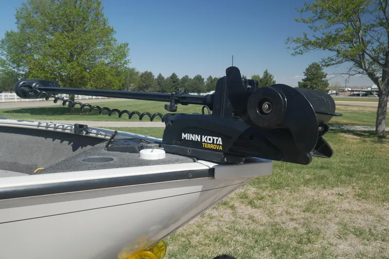 Slide: The Image of 2018 Tracker Pro Guide V-165 WT boat with Minn Kota Terrova trolling motor in a grassy area. - 2