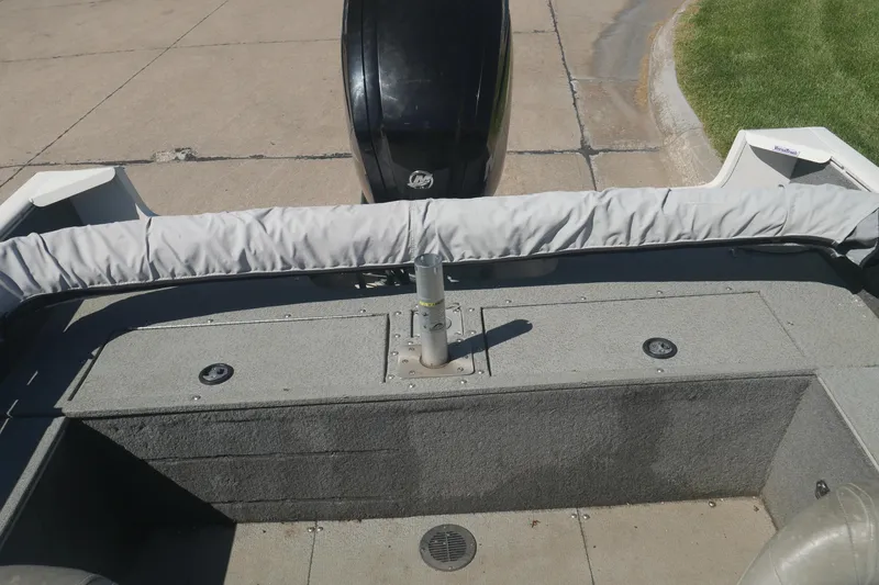 Slide: The Image of 2018 Tracker Pro Guide V-165 WT boat interior with motor, docked on pavement. - 7