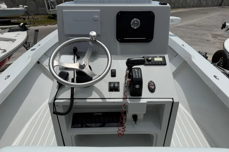 Slide: The Image of 2023 Exuma 22 boat dashboard with steering wheel and control panel. - 11