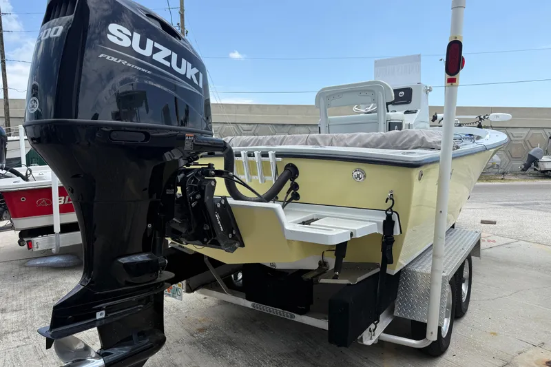 Slide: The Image of 2023 Exuma 22 boat with Suzuki outboard motor on trailer, parked outdoors. - 4