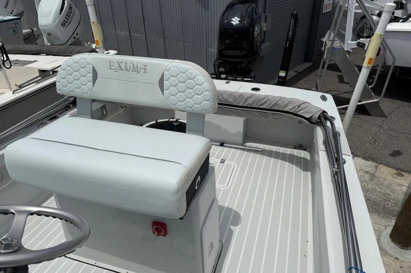 Slide: The Image of 2023 Exuma 22 boat interior with cushioned seating and steering wheel, showcasing modern design. - 9