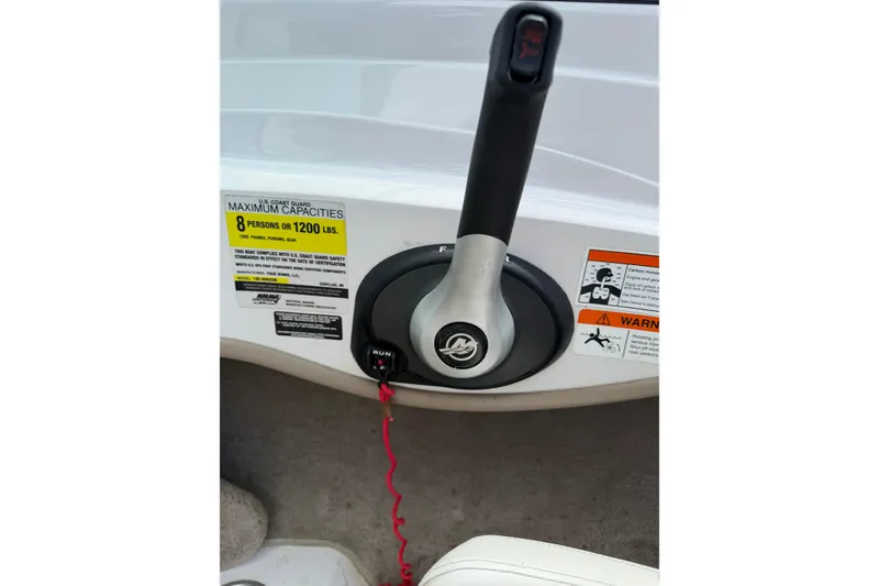 Slide: The Image of Throttle control of 2011 Four Winns H190 boat with capacity warning labels. - 16