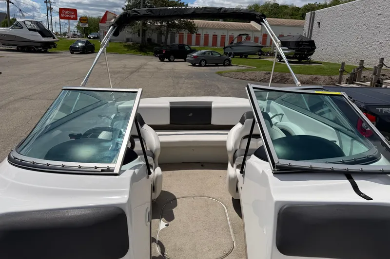 Slide: The Image of 2011 Four Winns H190 boat interior with open windshield, parked outdoors. - 7